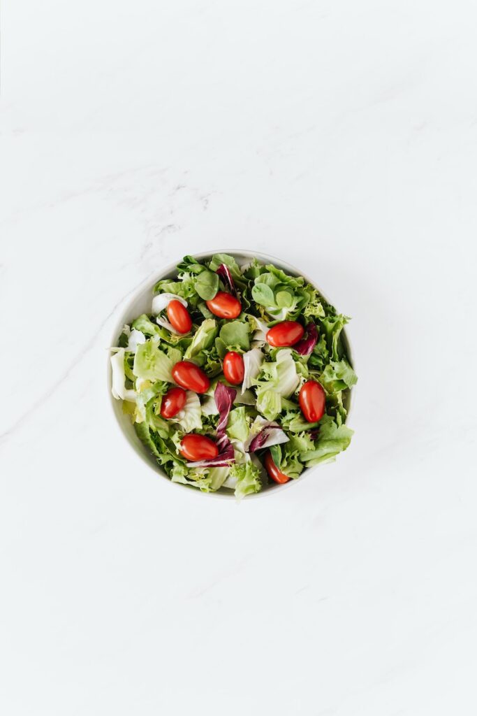 Bowl of fresh vegetable salad on table